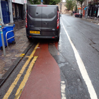 A photo of a bike lane with a car in it