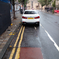 A photo of a bike lane with a car in it