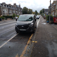 A photo of a bike lane with a car in it