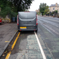 A photo of a bike lane with a car in it