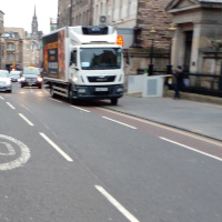 A photo of a bike lane with a car in it